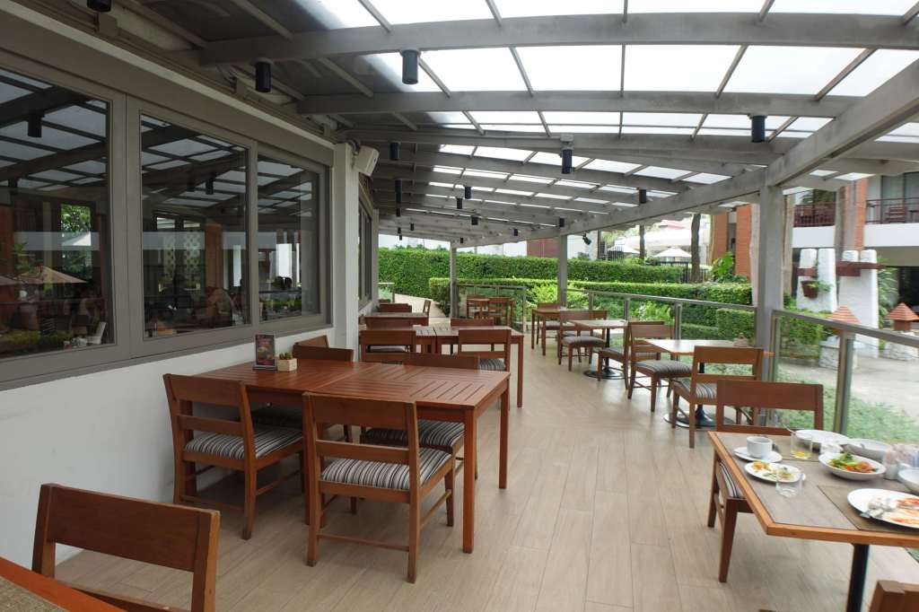 Outdoor restaurant seating at Woodlands Hotel & Resort in Pattaya, Thailand.