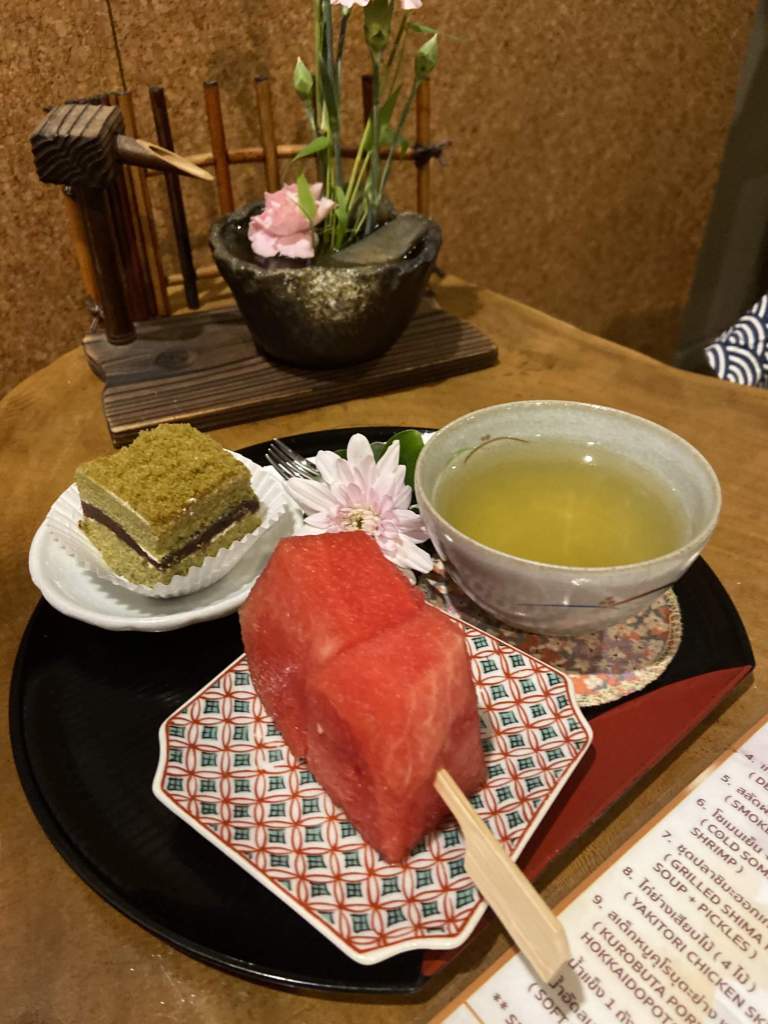 Cake and green tea on tray at Kashikiri Soda Onsen and Spa, Bangkok.