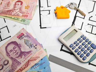Money and calculator on the table for buying an apartment in Thailand.