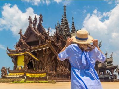 Tourist standing in front of Pattaya Sanctuary of Truth in Thailand.