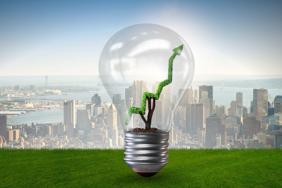 Green-energy light bulb against city backdrop.