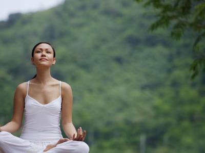 Woman meditating outdoors.
