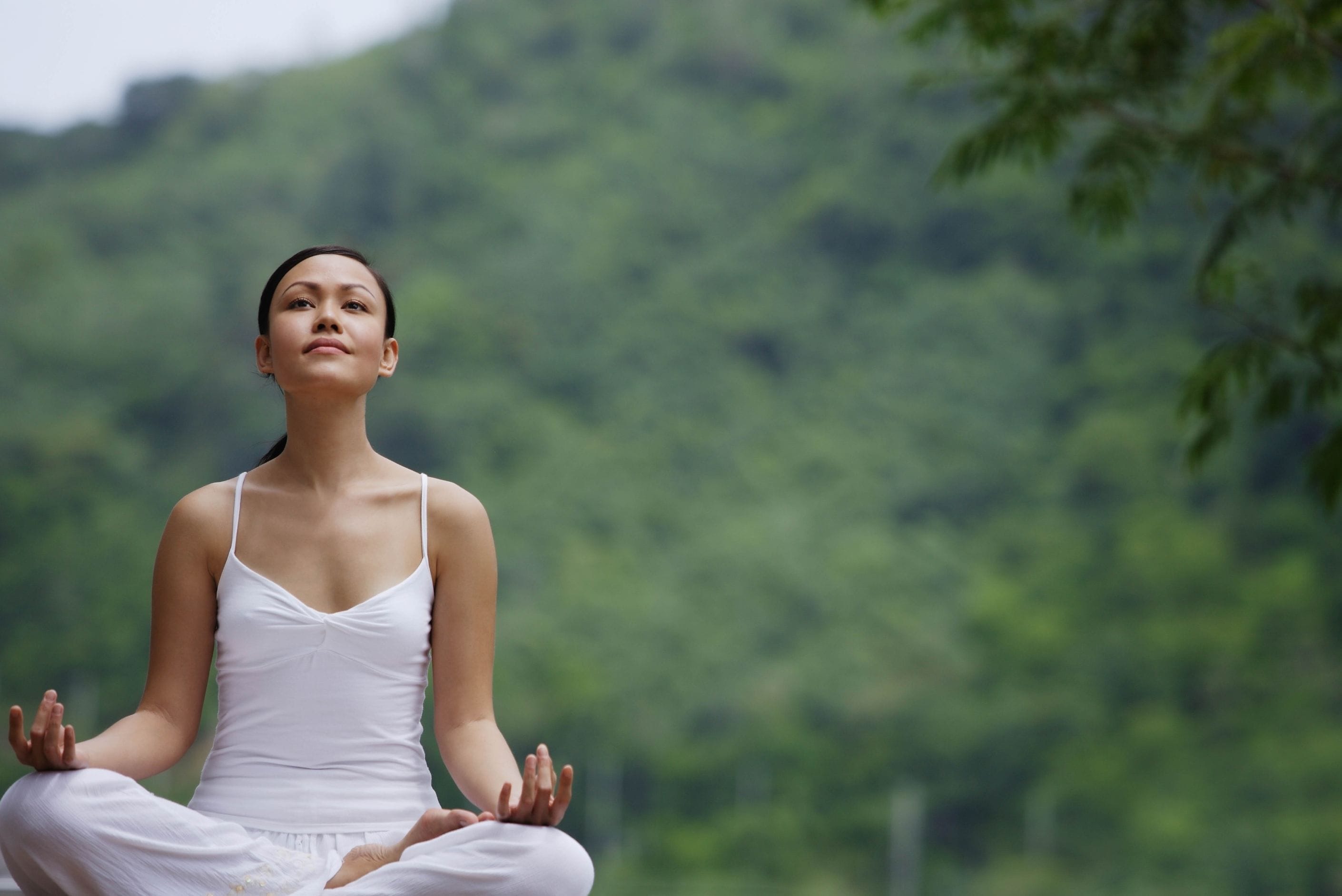 Woman meditating outdoors.
