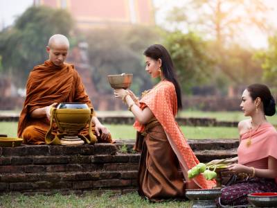Two women praying with monk.
