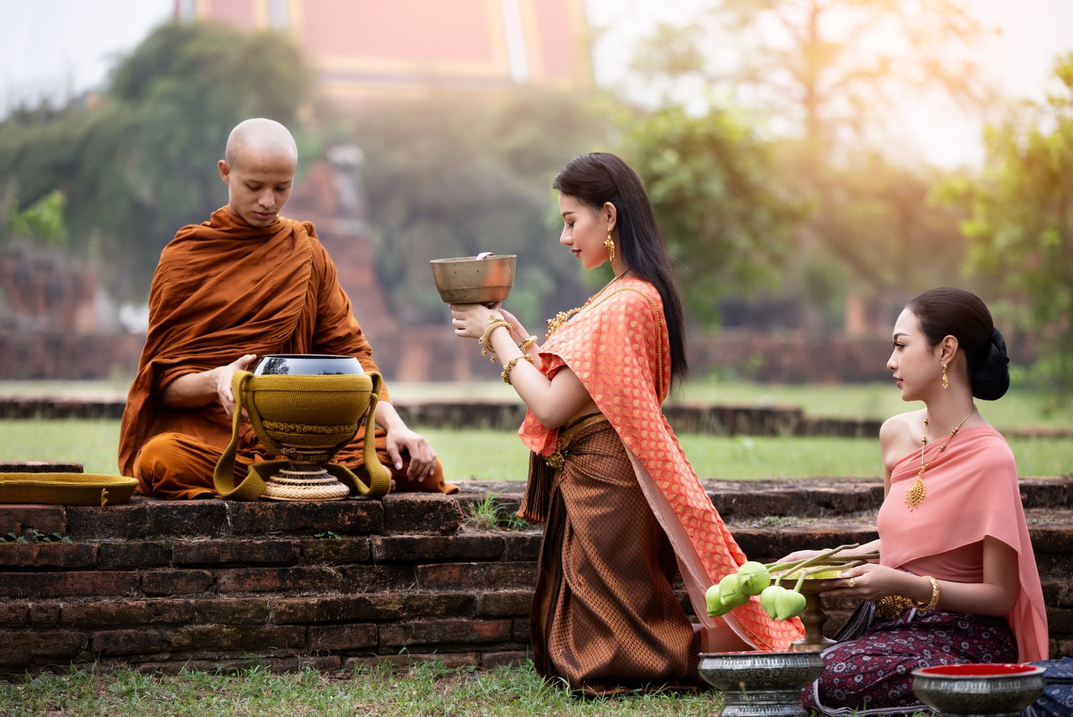 Two women praying with monk.