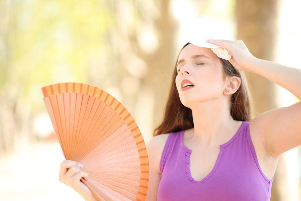 Woman fanning herself in the heat.
