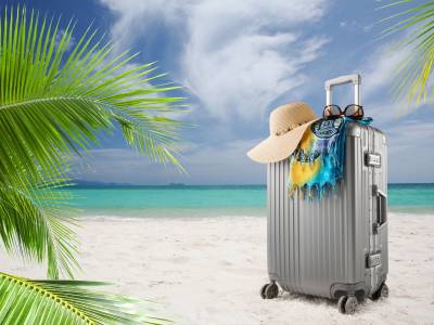 Suitcase on sandy tropical beach.