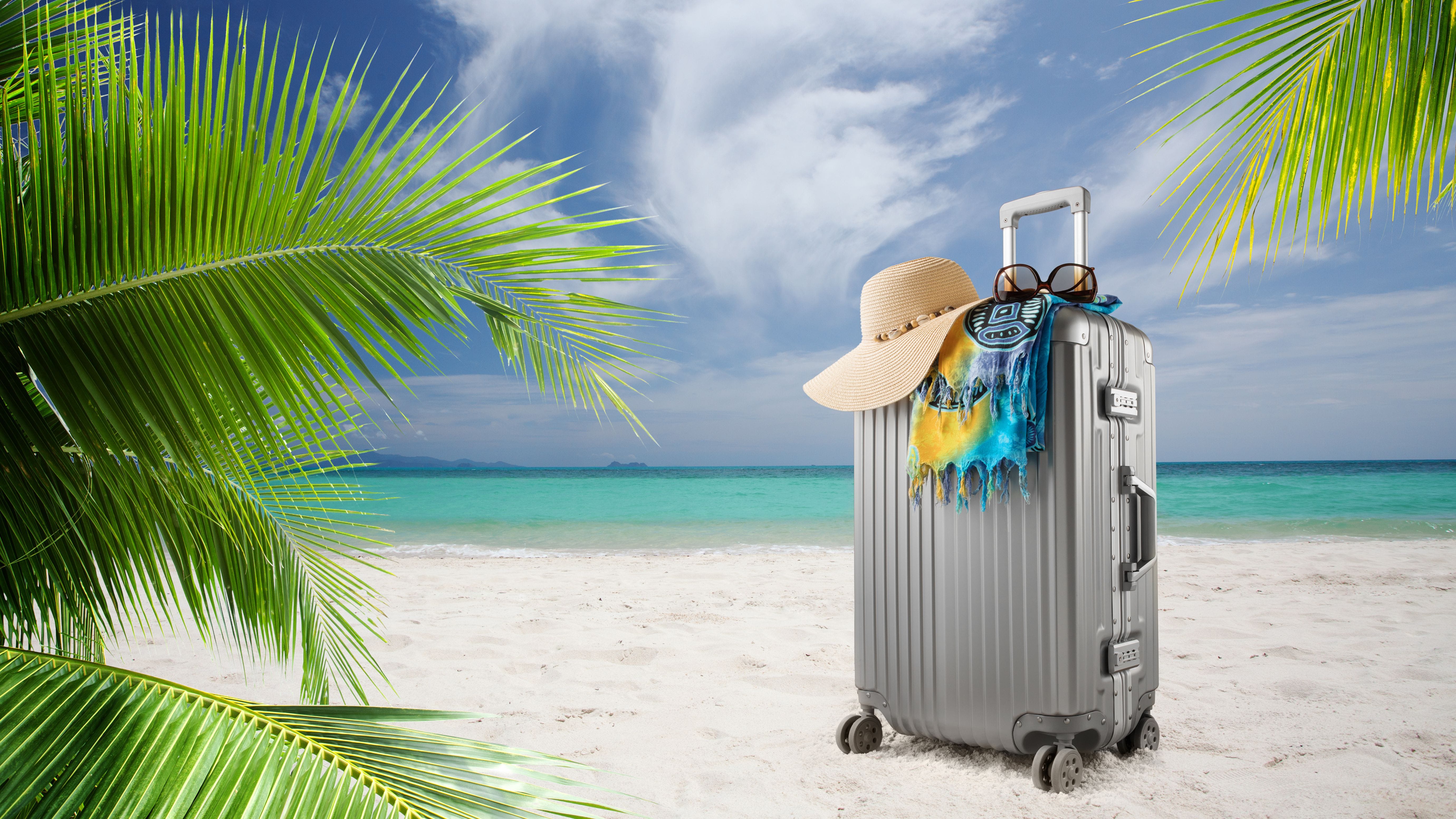 Suitcase on sandy tropical beach.