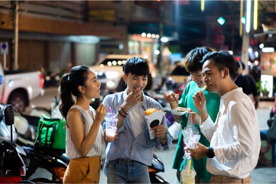 Thai people eating street food together in a group.