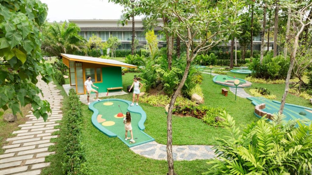 Family playing mini golf at Avani+ Khao Lak Resort in Thailand.