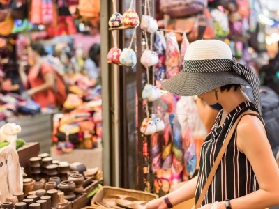 Woman browsing goods at Chatuchak Weekend Market in Bangkok.
