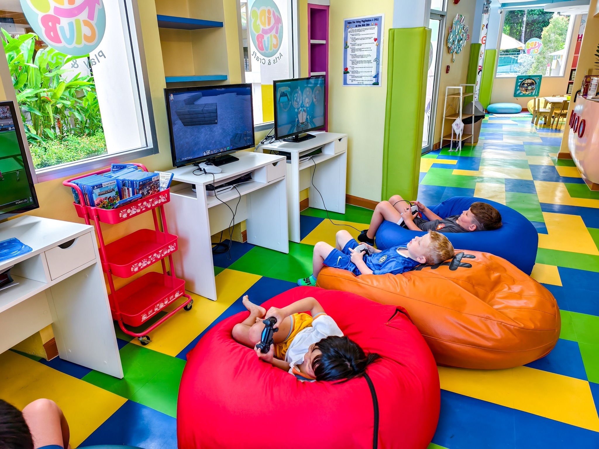 Children lying on beanbags playing video games at Holiday Inn Resort Phuket in Thailand.