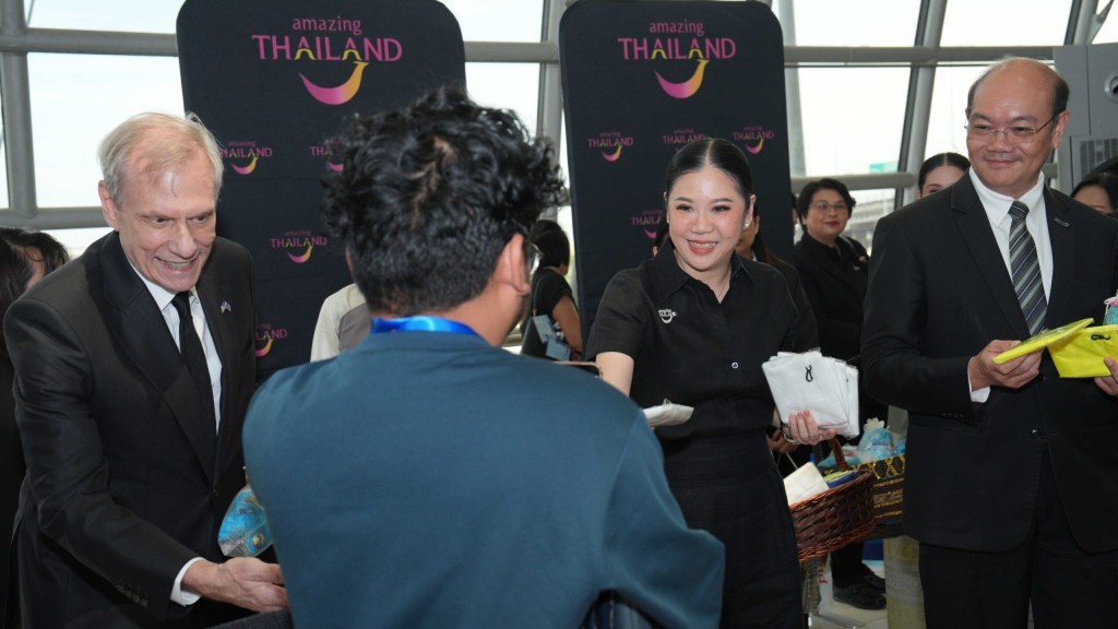 TAT representatives greet travelers from the United Airlines inaugural Los Angeles–Bangkok flight with welcome gifts.