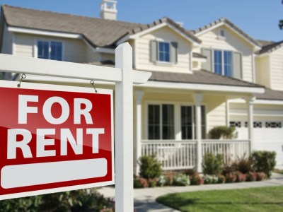A 'FOR RENT' sign outside a house.