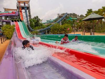Boys sliding down slides at Ramayana Water Park in Thailand.