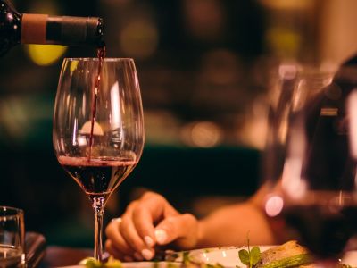 Close-up of wine being poured from a bottle into a glass at a restaurant.