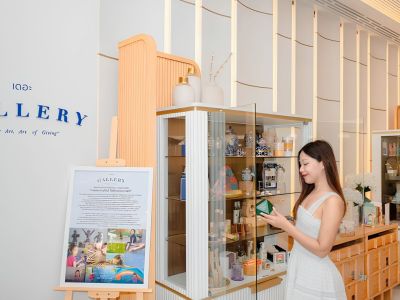 Asian woman examining one of the art pieces in a glass display at The GALLERY at Meliá Pattaya Hotel in Thailand.