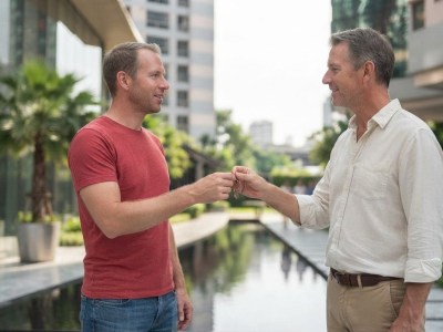 A new tenant receives the keys from his landlord in the grounds of a condo complex in Bangkok.